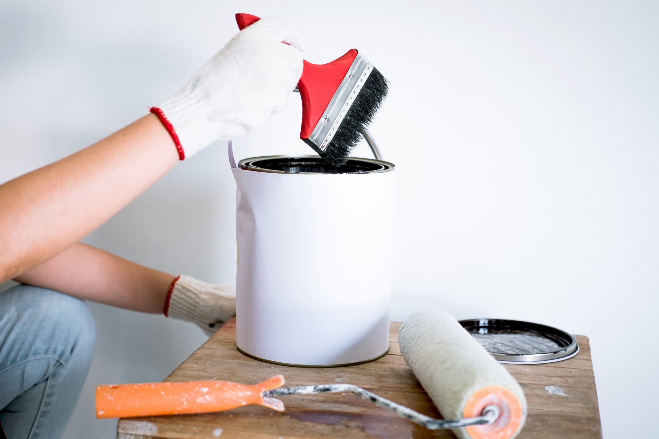 Interior working, Painter hand in white glove painting wall with paint brush in room, shape and structure.