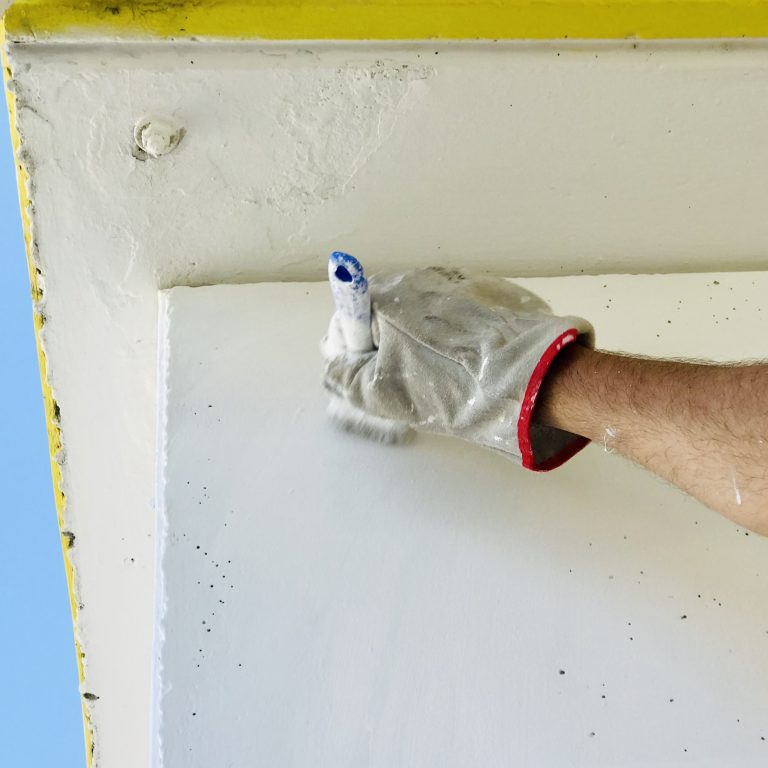 hand-man-holding-painting-white-wall