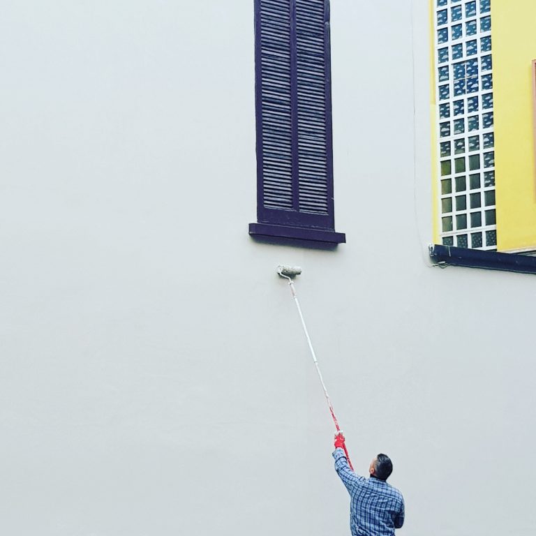 low-angle-view-man-painting-white-wall
